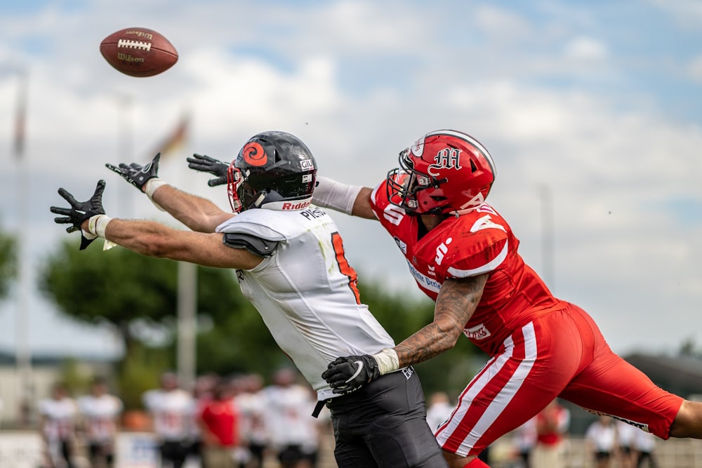 college-football-player-reaching-for-ball-and-cornerback